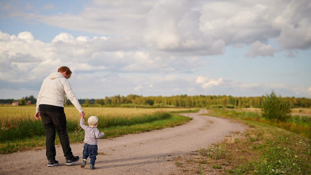 Nainen ja pikkulapsi kävelevät polulla, kuvituskuva